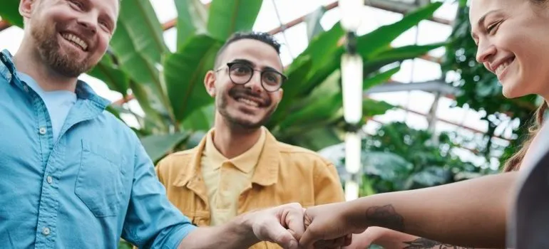 Three friends are bumping fists