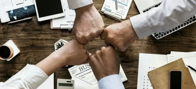 A group of people fist-bumping.
