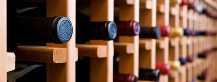 Bottles of wine neatly stacked inside large wine shelves.
