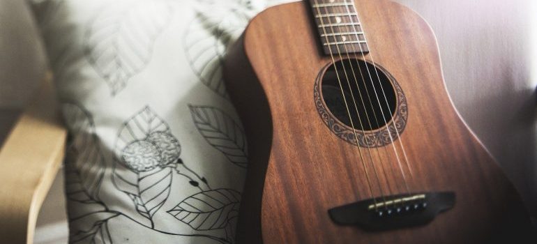 A guitar on an armchair.