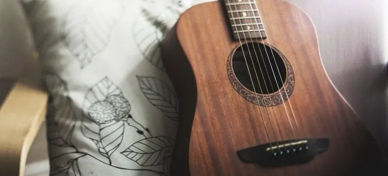 A guitar on an armchair. 