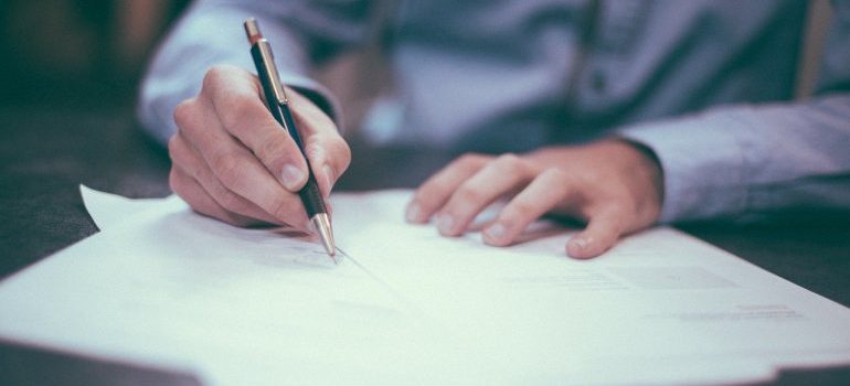 A person writing a contract for renting a mobile storage unit in Washington