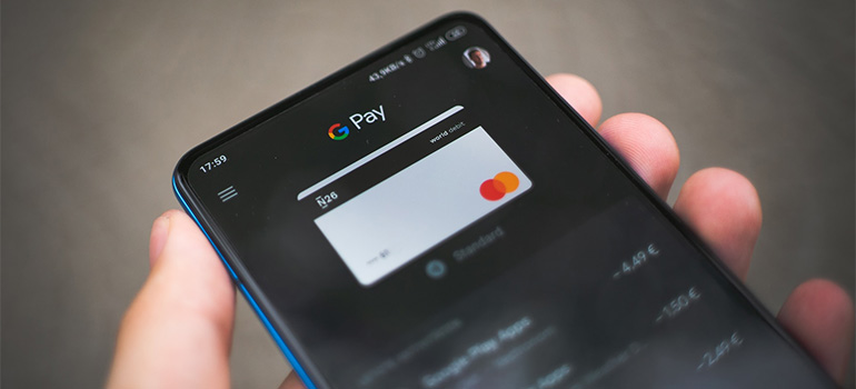 A person holding a smarphone with a google pay option open