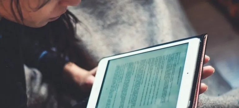A woman reading something on a tablet.