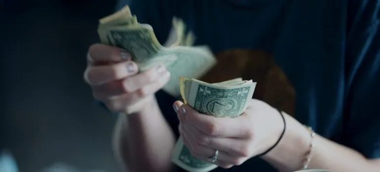 person counting dollar bills
