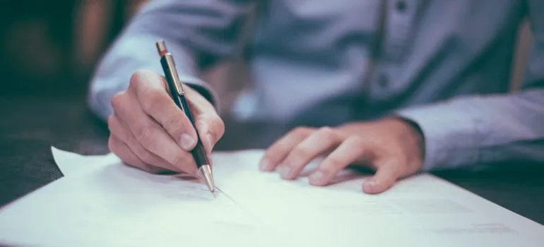 person filling out paperwork on a desk