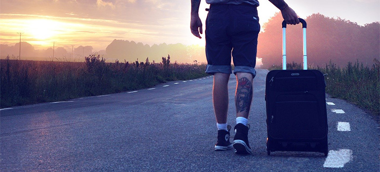 A man with a suitcase, trying to move abroad on a budget