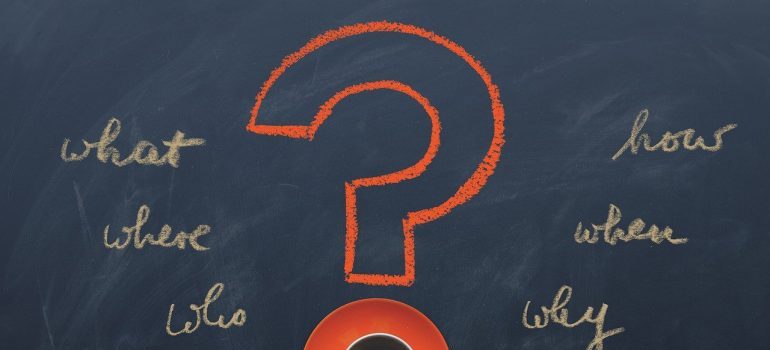 A question mark and words written on a blackboard.