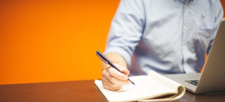A man sitting and writing a plan for moving from Seattle to Redmond.