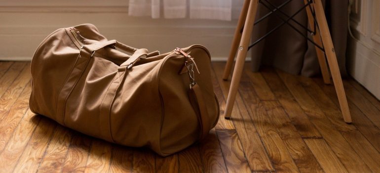 A brown bag next to a chair in which to pack an essentials box when moving.
