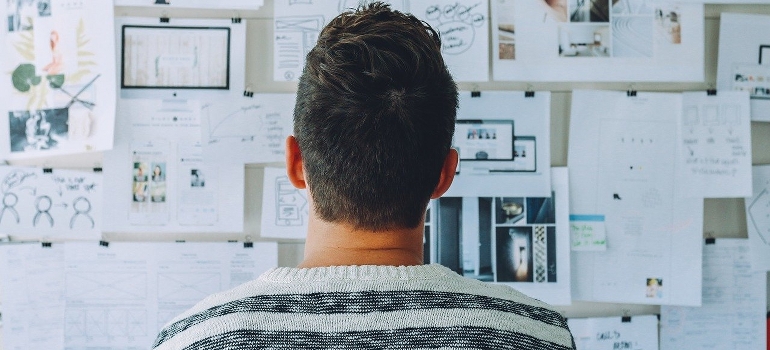 A man looking up on plans on a whiteboard.