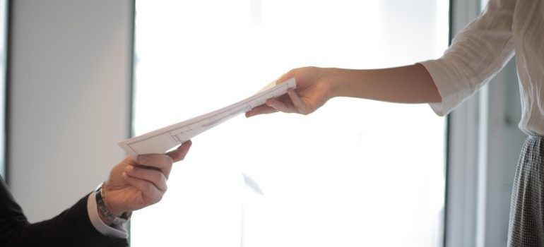 A man handing off a piece of paper to a woman.