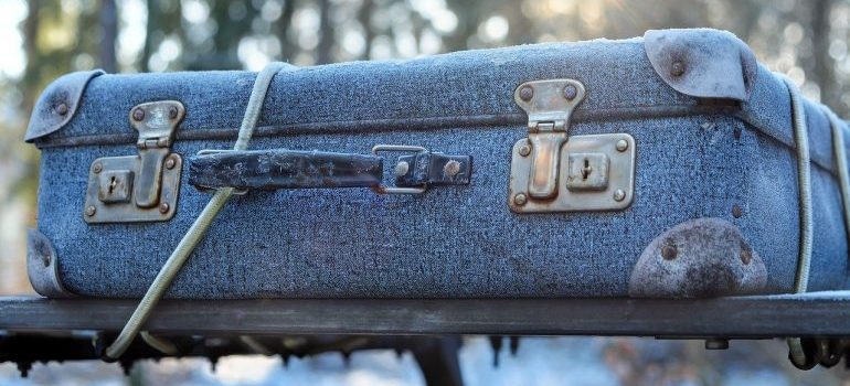 A blue suitcase on a car.