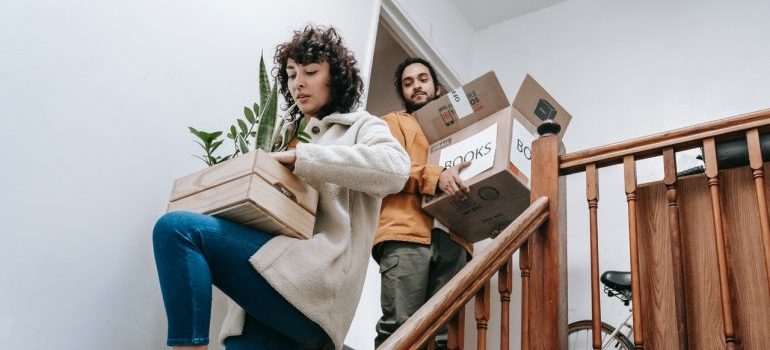Couple carrying moving boxes