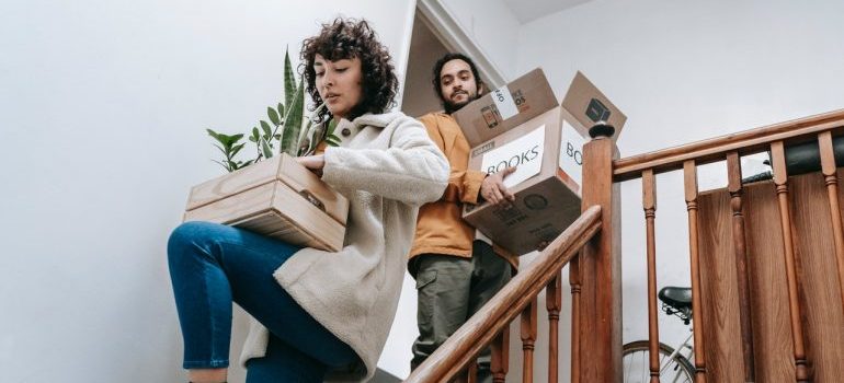 A couple carrying their belongings to a storage unit.