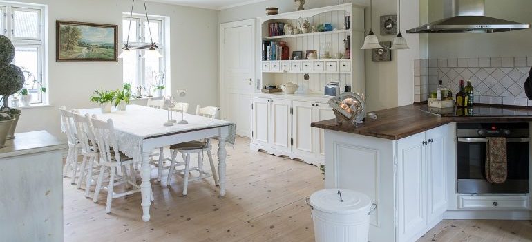 A white, rustic kitchen with a lot of storage space.