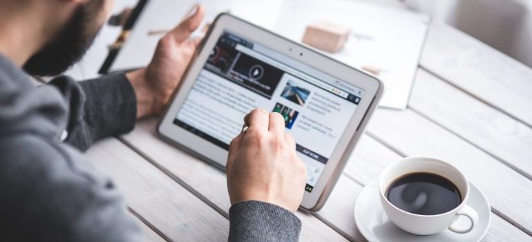 Man reading an article on moving as a student on his tablet