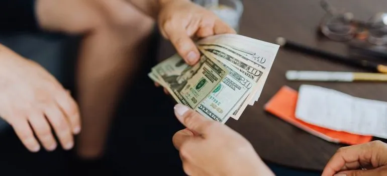 person handing money to another person