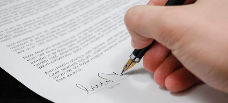 A person signing a binding long distance moving estimate.