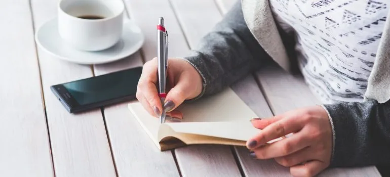 A woman making an inventory list because that makes storing office furniture and supplies much easier.
