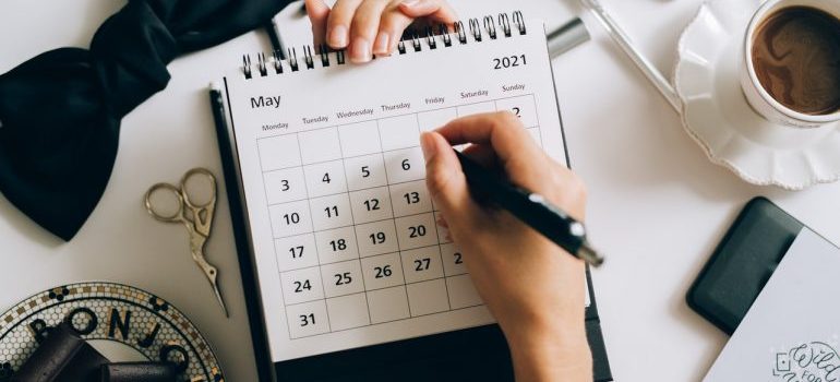 Person writing on a calendar