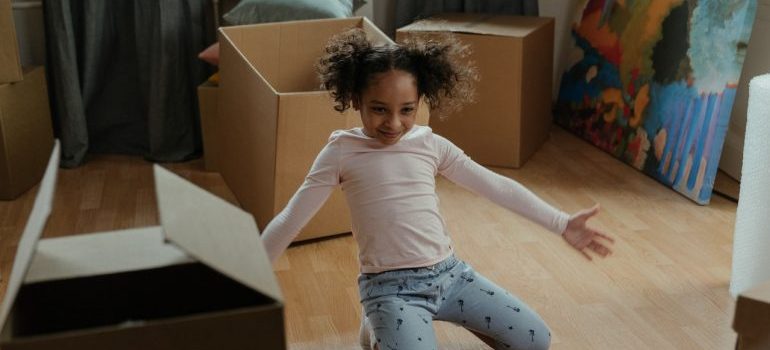 A smiling kid among moving boxes.