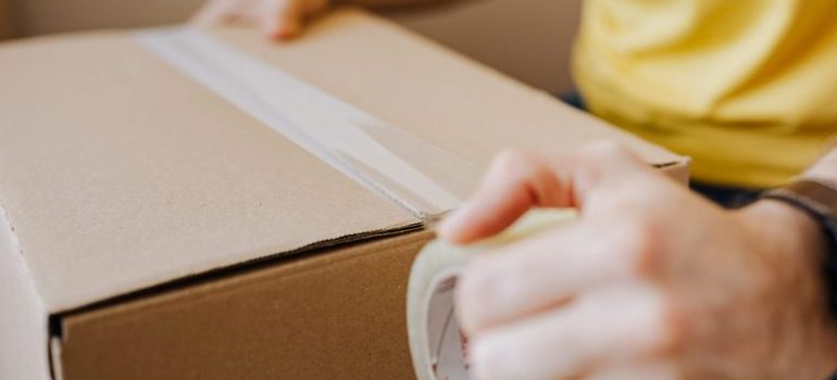 person taping a box