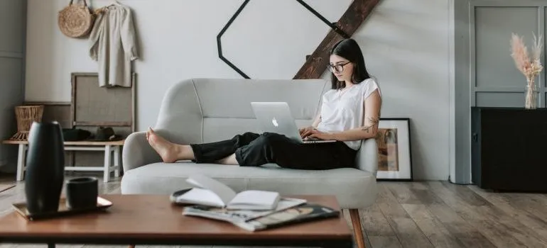 Woman using laptop to research ways of moving without damaging her home.