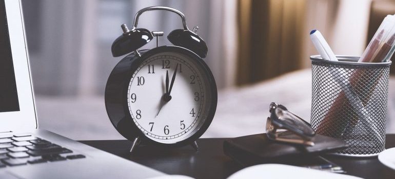 A black alarm clock on the table.