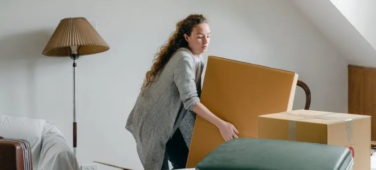 Woman trying to lift a heavy box