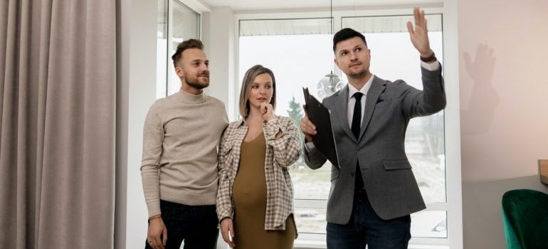 A couple and a real estate agent touring a home