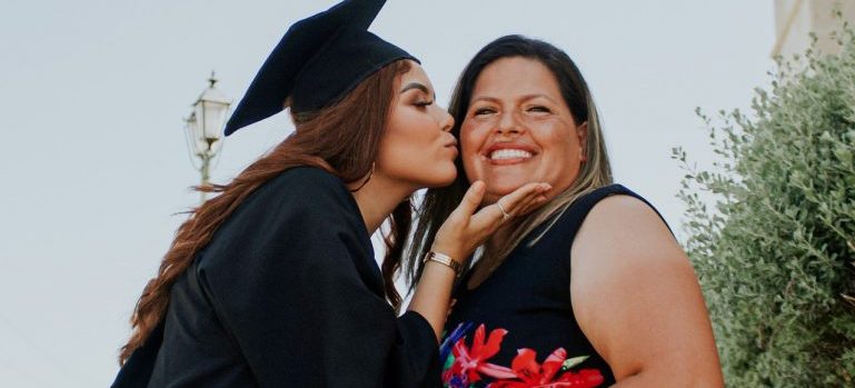 a college graduate kissing her mum