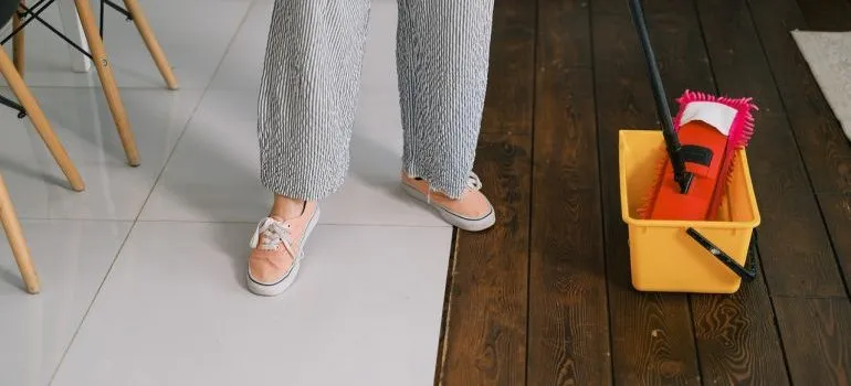 A woman cleans the floors.