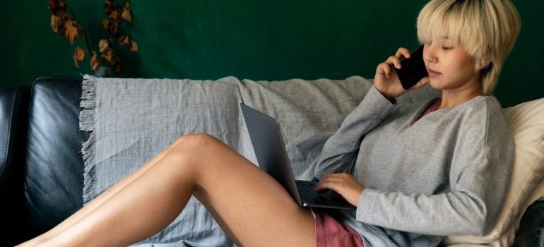 A woman with a laptop talking on the phone