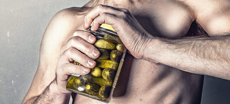 person opening a pickle jar