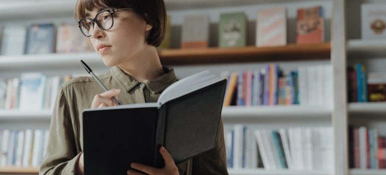 a woman holding a book and a pen
