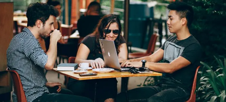 three students sitting in a cafe