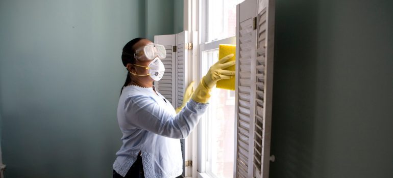 a woman cleaning window shutters