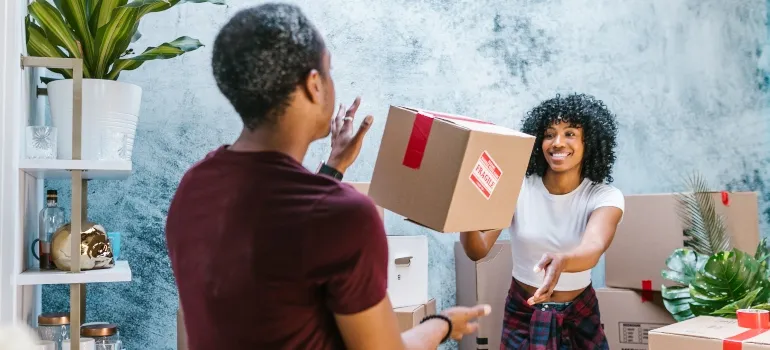 a couple talking about signs of a successful Seattle relocation while packing for the move