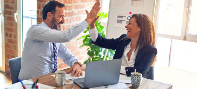 man and woman high fiving in the office