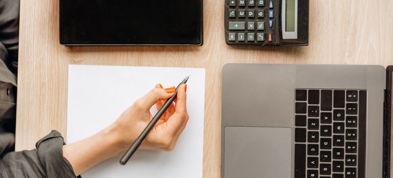 Laptop, pen, and calculator on the table