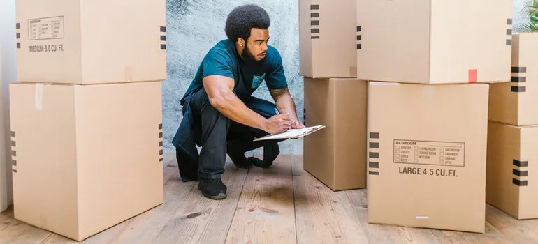 A mover looking at the prepared moving boxes