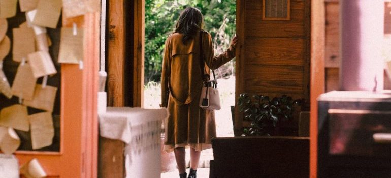 A woman standing at the door of the cabin, thinking how to decorate her vacation home on a budget