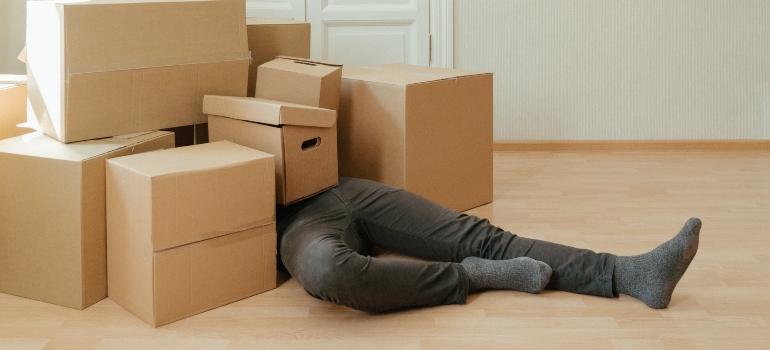 man covered with moving boxes