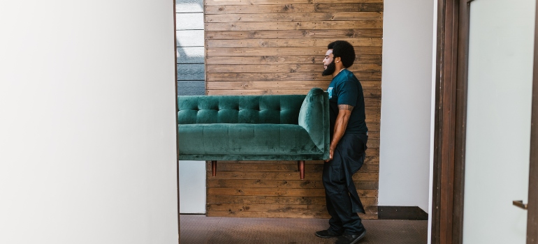random guy carrying big green sofa