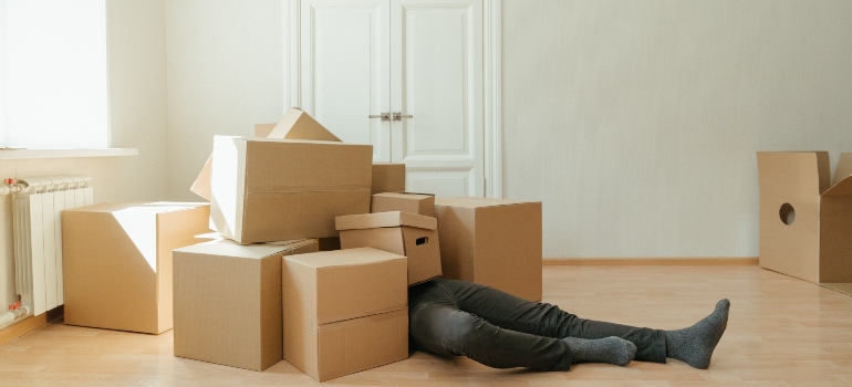 A man cluttered by boxes not knowing the benefits of portable storage units