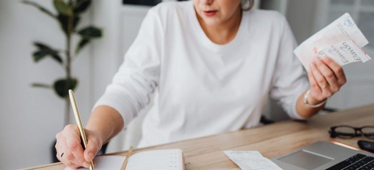 A woman writing and thinking about how to pack family heirlooms