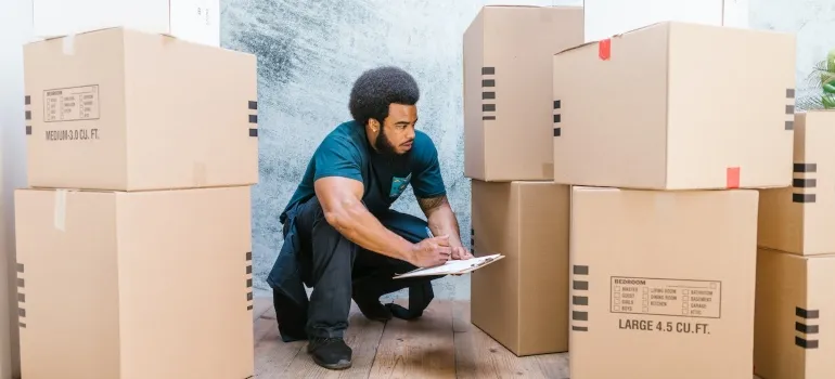 A mover holding an inventory list for shipping your belongings from Seattle