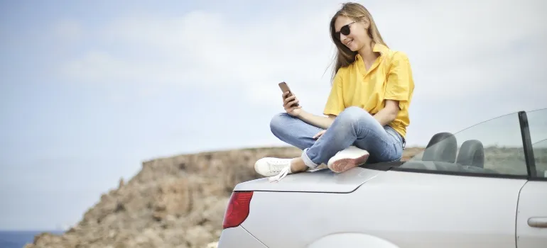 A woman sitting on a car