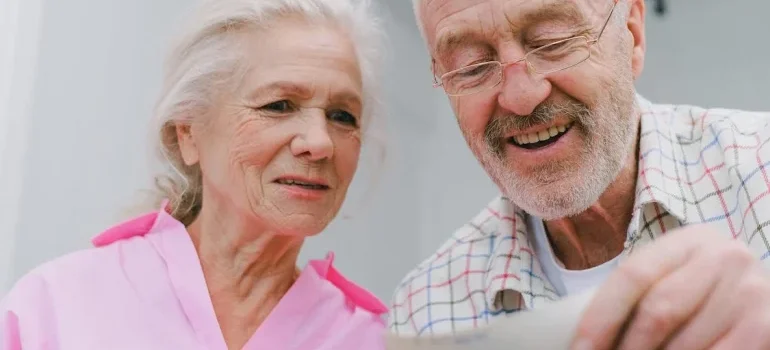 An elderly couple looking at the photo and thinking about storing books and photos